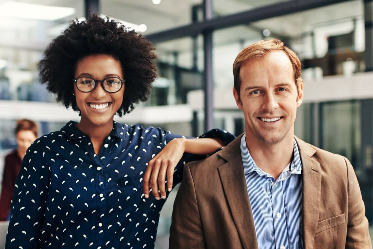 African American woman and white man smiling as coworkers